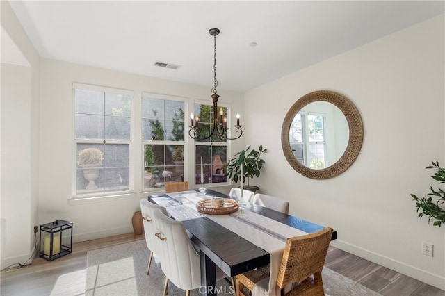 dining area featuring a wealth of natural light, light hardwood / wood-style flooring, and a chandelier