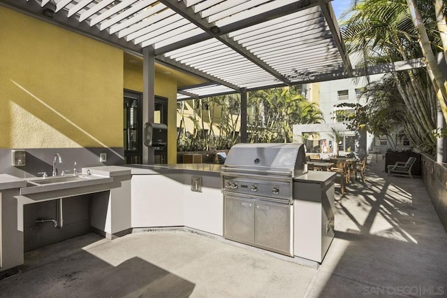 view of patio featuring an outdoor kitchen, a pergola, and a grill