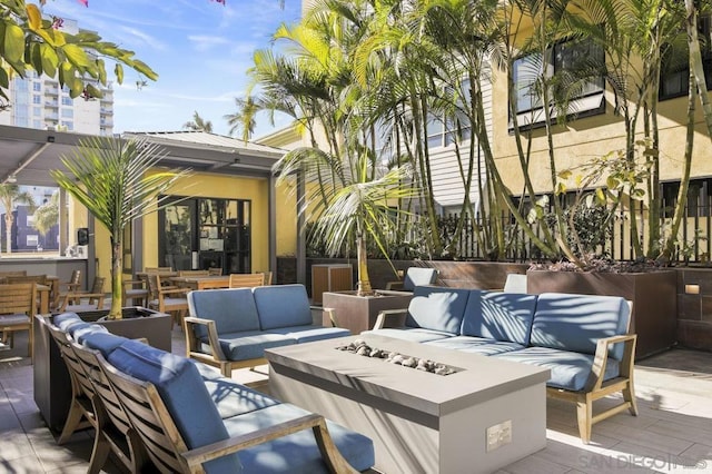 view of patio with an outdoor living space with a fire pit