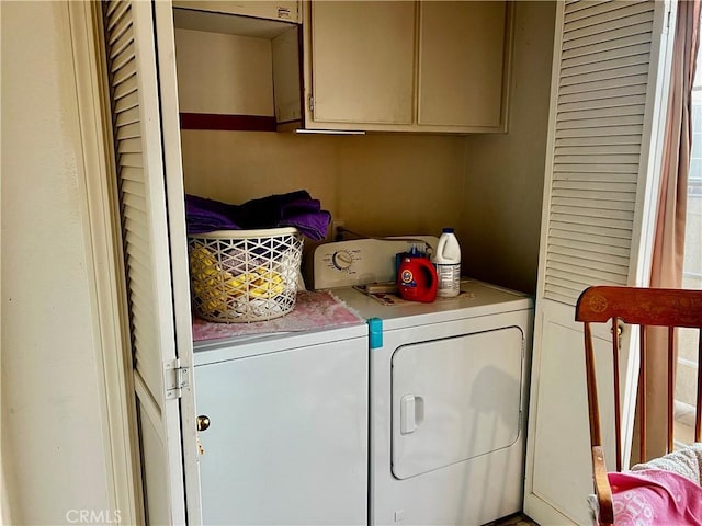 washroom with cabinets and washing machine and clothes dryer