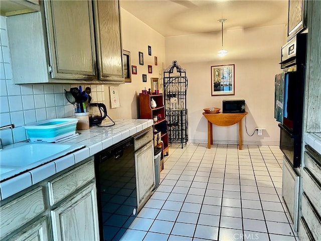 kitchen with pendant lighting, backsplash, tile counters, light tile patterned floors, and black appliances