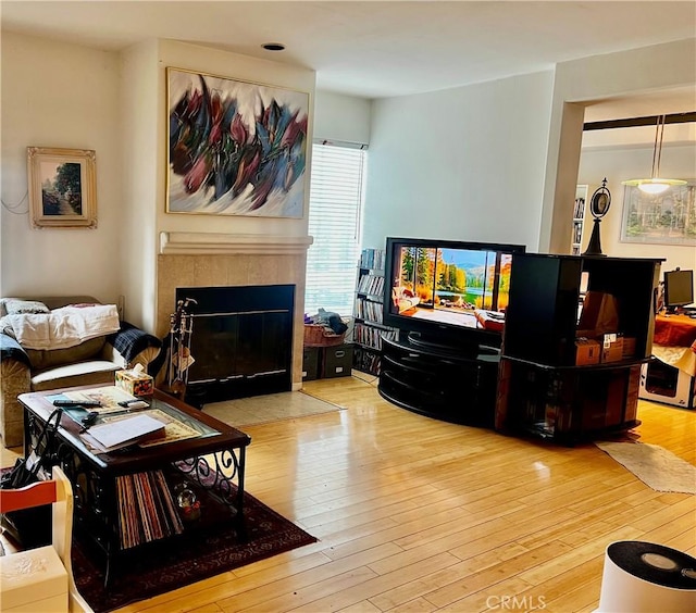 living room featuring light hardwood / wood-style flooring and a tile fireplace