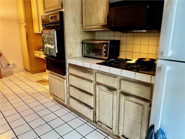 kitchen featuring light tile patterned flooring, tile countertops, backsplash, and white appliances