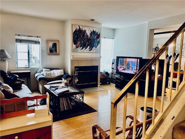 living room featuring a tile fireplace and light hardwood / wood-style flooring