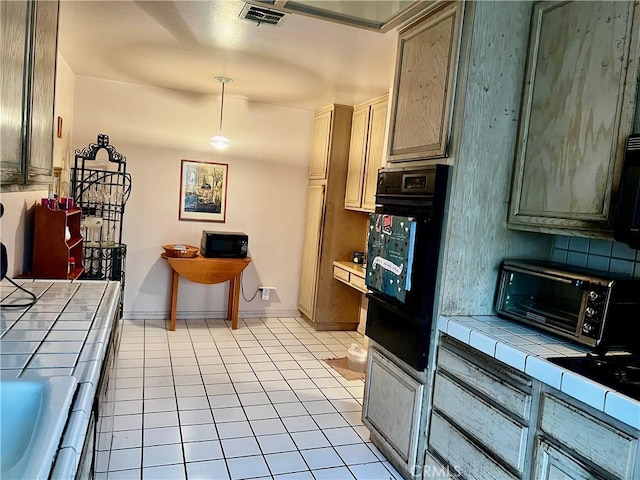 kitchen with light tile patterned flooring and tile countertops