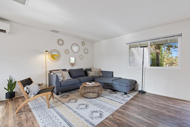 living room with a wall mounted AC and wood-type flooring