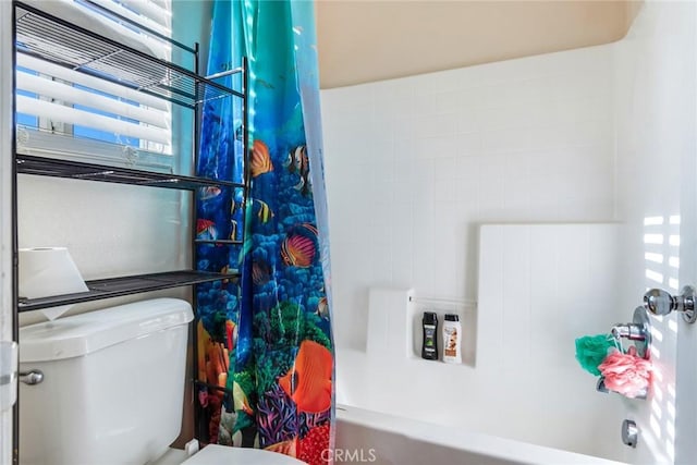 bathroom with shower / tub combo with curtain and toilet