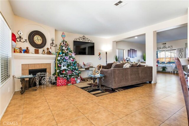 living room featuring a tiled fireplace and tile patterned flooring