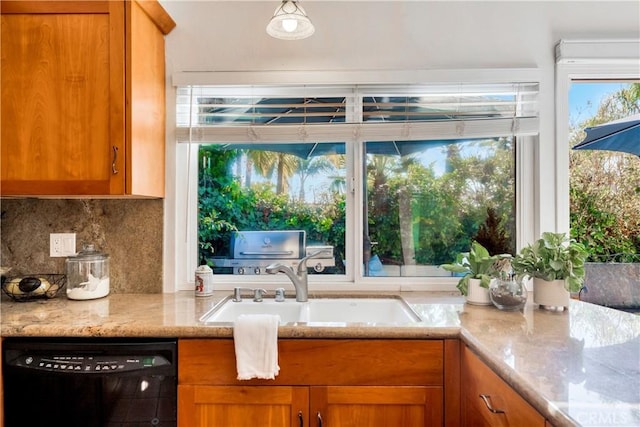 kitchen featuring light stone countertops, decorative backsplash, dishwasher, and sink