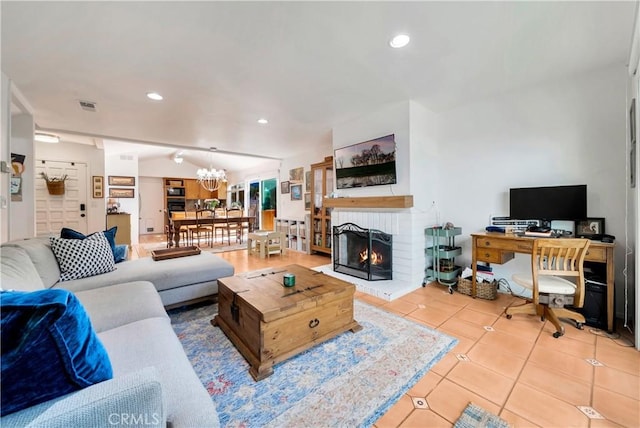 living room with a brick fireplace, light tile patterned floors, and a notable chandelier