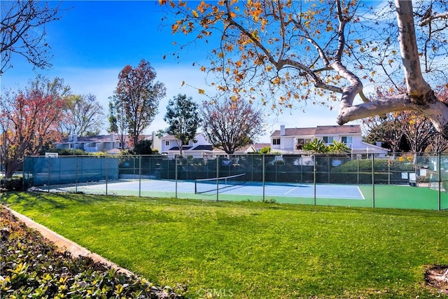 view of tennis court featuring a yard