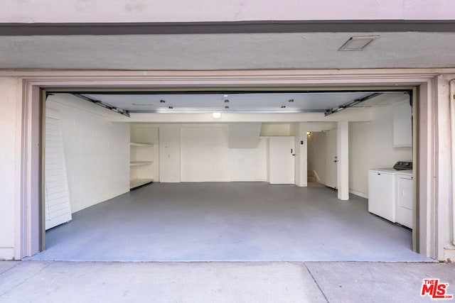 garage featuring washing machine and clothes dryer