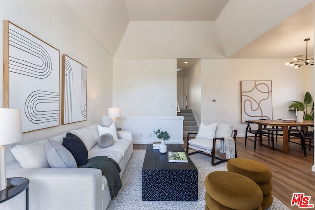 living room with lofted ceiling, wood-type flooring, and a notable chandelier