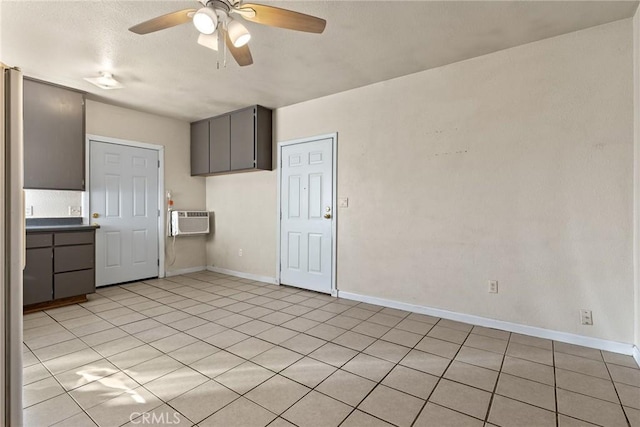 kitchen with ceiling fan, light tile patterned floors, and an AC wall unit