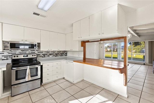 kitchen featuring backsplash, white cabinetry, stainless steel appliances, and light tile patterned flooring