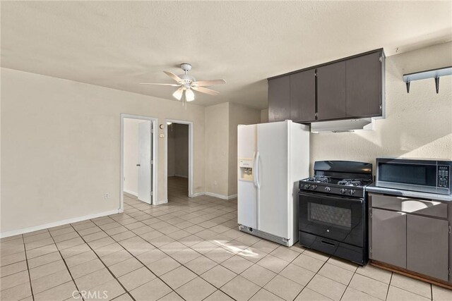 kitchen featuring ceiling fan, light tile patterned flooring, gas stove, and white fridge with ice dispenser