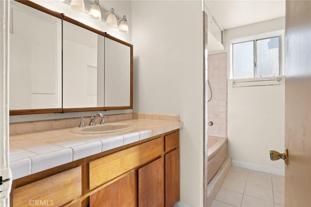 bathroom with vanity, tile patterned flooring, and tiled shower / bath combo