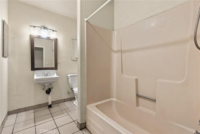 bathroom with toilet, shower / bathing tub combination, and tile patterned floors