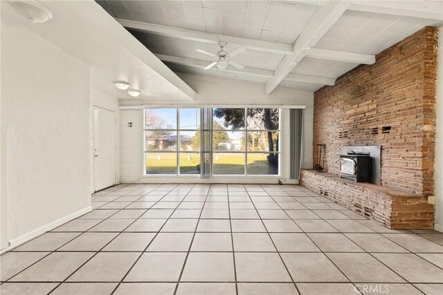 unfurnished living room with ceiling fan, lofted ceiling with beams, light tile patterned flooring, and a wood stove