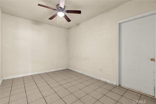 tiled spare room featuring ceiling fan