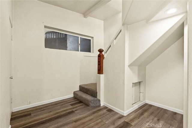 stairs with hardwood / wood-style flooring and beamed ceiling