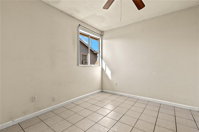 empty room with ceiling fan and light tile patterned floors