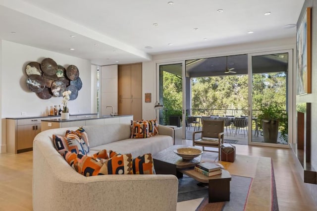 living room featuring ceiling fan and light hardwood / wood-style floors