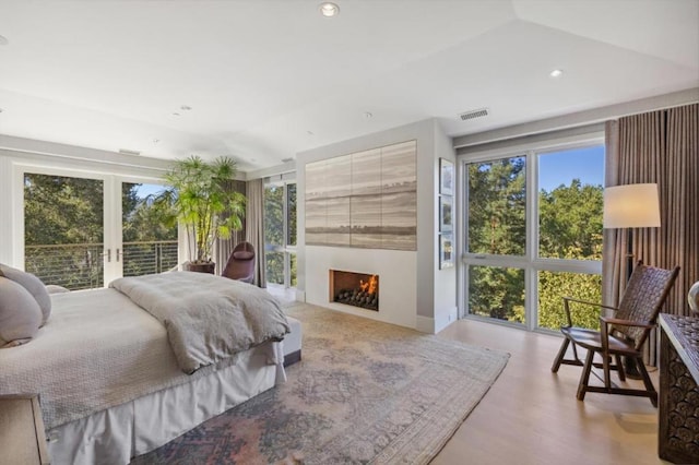 bedroom featuring access to outside, french doors, and light hardwood / wood-style flooring