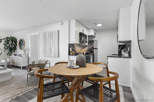 dining space featuring hardwood / wood-style flooring and sink