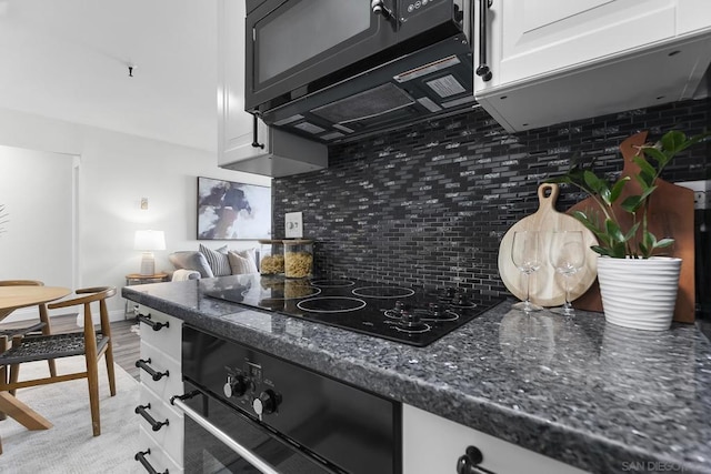 kitchen featuring wall oven, black electric stovetop, backsplash, and white cabinets