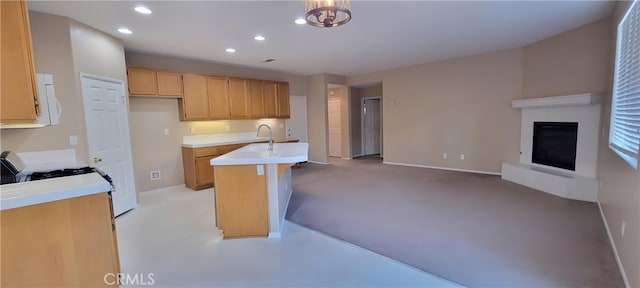 kitchen featuring a kitchen breakfast bar, light brown cabinetry, pendant lighting, a tile fireplace, and sink