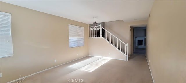 stairs with carpet flooring and a notable chandelier