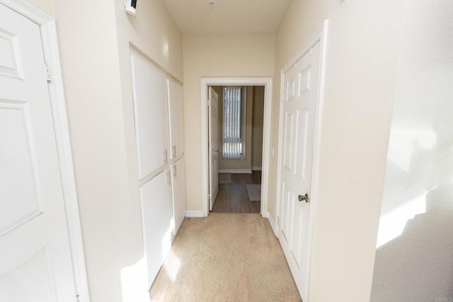 hallway featuring light colored carpet