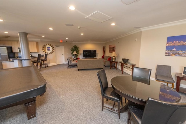 carpeted dining room featuring ornamental molding and ornate columns