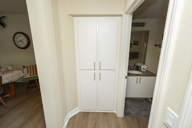 corridor with sink and light hardwood / wood-style floors