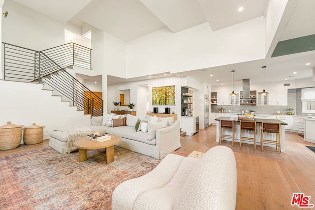 living room featuring light hardwood / wood-style flooring and a towering ceiling