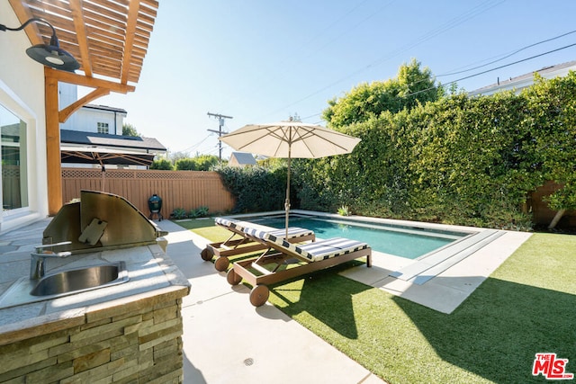 view of pool with area for grilling, sink, a yard, a pergola, and a patio