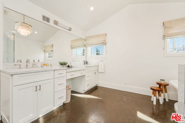 bathroom featuring an inviting chandelier, lofted ceiling, and vanity