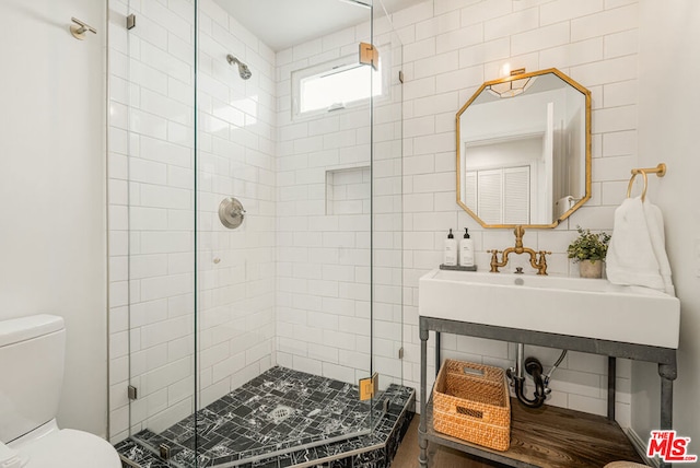 bathroom with toilet, a shower with door, and tasteful backsplash