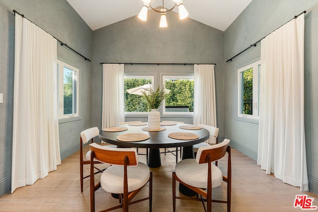 dining area with a chandelier, lofted ceiling, and light hardwood / wood-style flooring