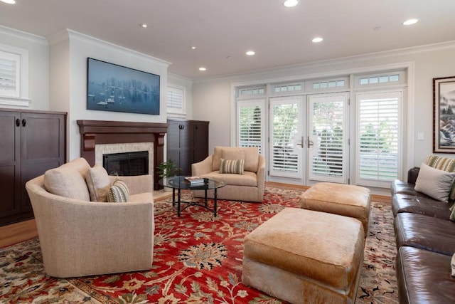 living room featuring crown molding, a high end fireplace, and light hardwood / wood-style flooring