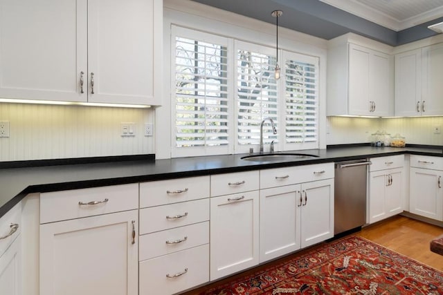 kitchen featuring sink, crown molding, stainless steel dishwasher, and white cabinets