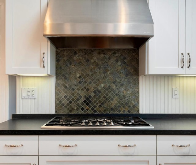 kitchen with decorative backsplash, exhaust hood, white cabinets, and stainless steel gas cooktop