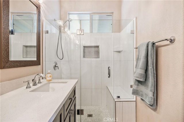 bathroom with a shower with shower door and vanity