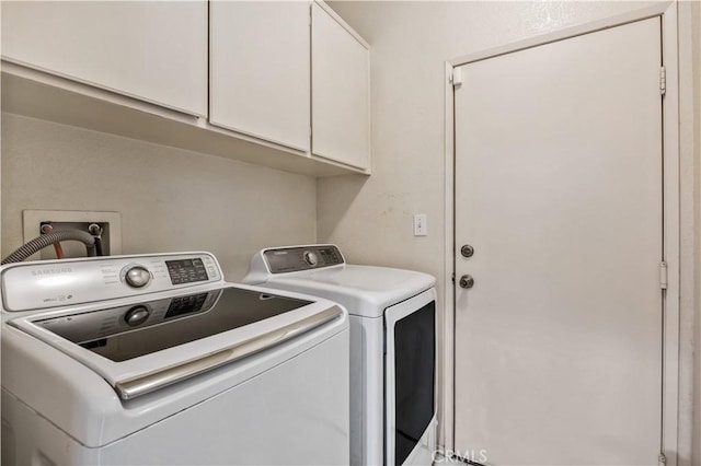 laundry area with washer and clothes dryer and cabinets