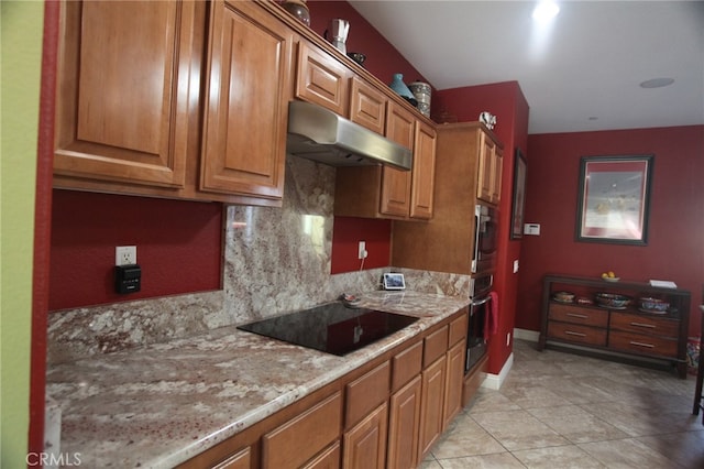 kitchen with stainless steel oven, black electric cooktop, light stone countertops, and decorative backsplash