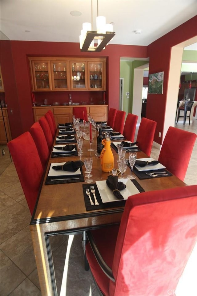 tiled dining room with an inviting chandelier