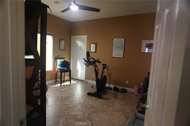 workout area featuring light tile patterned floors and ceiling fan