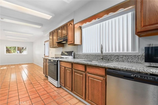 kitchen featuring white gas range, sink, light tile patterned floors, and dishwasher