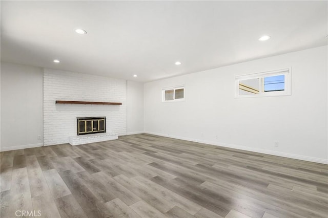 unfurnished living room featuring light wood-type flooring and a fireplace